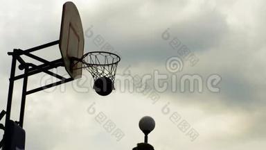 篮球运动员在运动场上用篮圈投掷球。 运动员在户外环形投掷球。 篮球比赛缓慢